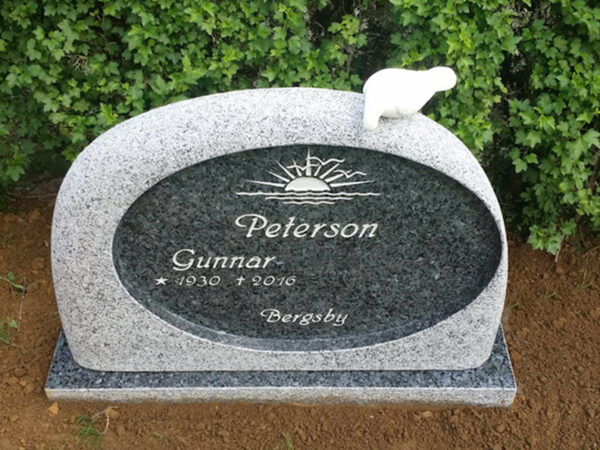 E059 finhuggen labrador granit med polerad spegel. Försänkt antikvit text och marmorduva på toppen.