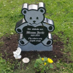 E050 in black granite. The engraving is recessed and painted white.