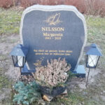 E016 in dark gray granite with gilded engraving. Polished front with rough-hewn edge detailing and side surfaces.