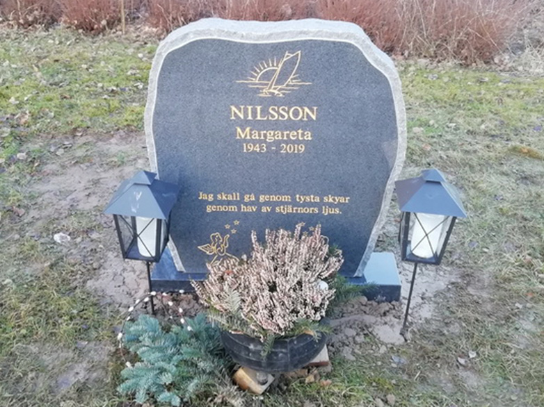 E016 in dark gray granite with gilded engraving. Polished front with rough-hewn edge detailing and side surfaces.