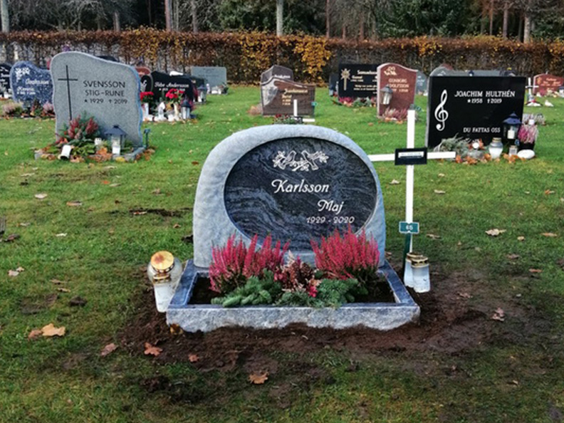 E059 i indisk blågrå granit. Försänkt antikvit gravyr samt blomlist med polerad ovansida och råarbetade sidytor.