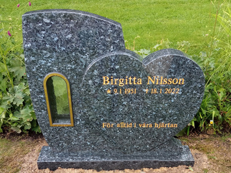 E044 in labrador granite. Recessed, gilded lettering and a bronze lantern.