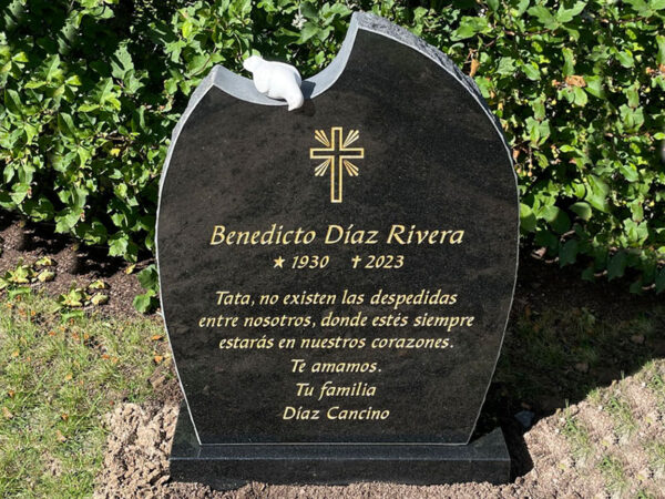 E047 in polished black granite with rough-hewn side surfaces. The engraving is recessed and gilded, with a marble dove at the top.