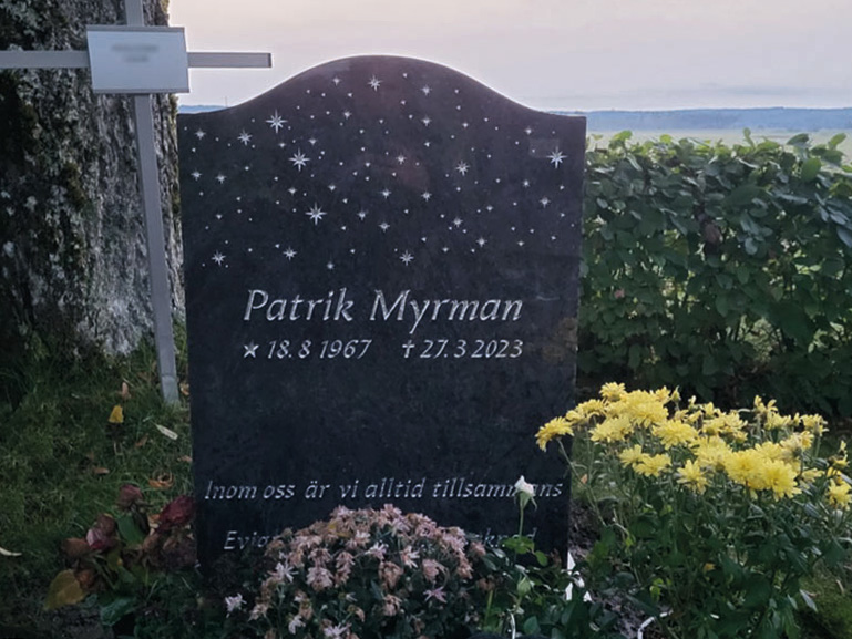 E009 in Indian blue-gray granite. Custom designed motif with recessed text painted silver.