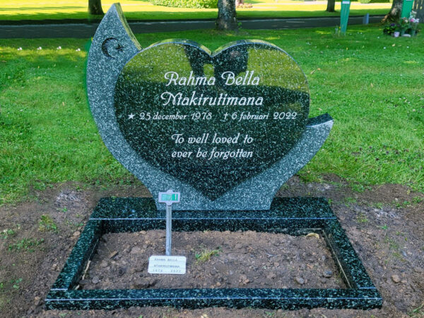 E080 in green-grey granite. Polished flower border, recessed black decoration, and recessed antique white text.