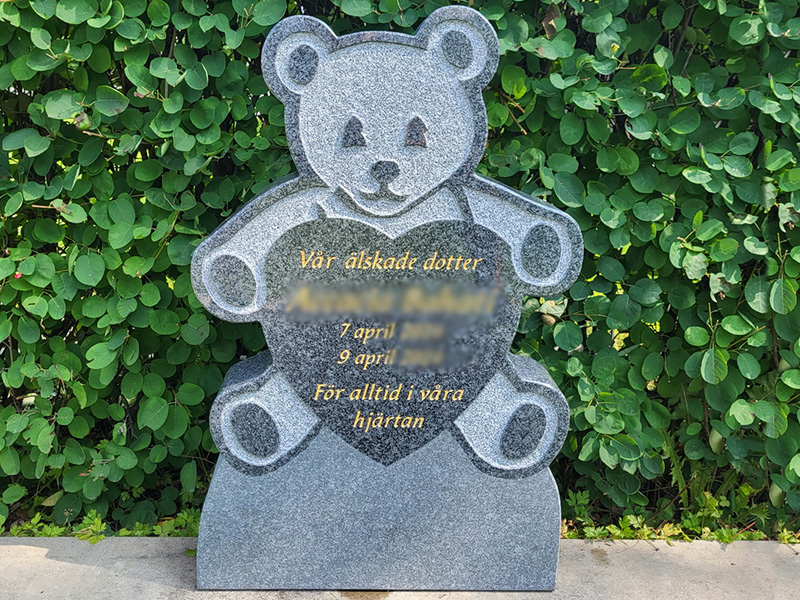 E050 in dark gray granite mounted on an existing beam. The engraving is recessed and gilded.