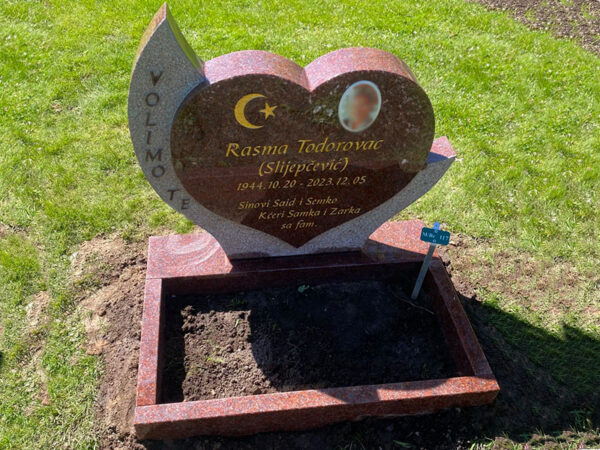 E080 in Indian red granite. Raised lettering on the side, recessed gilded engraving within the heart, polished flower border, porcelain photo.