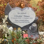 E080 in Indian blue-grey granite with alternative finishing. Raised lettering, polished flower border, with a granite vase attached on a granite base.