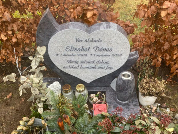 E080 in Indian blue-grey granite with alternative finishing. Raised lettering, polished flower border, with a granite vase attached on a granite base.