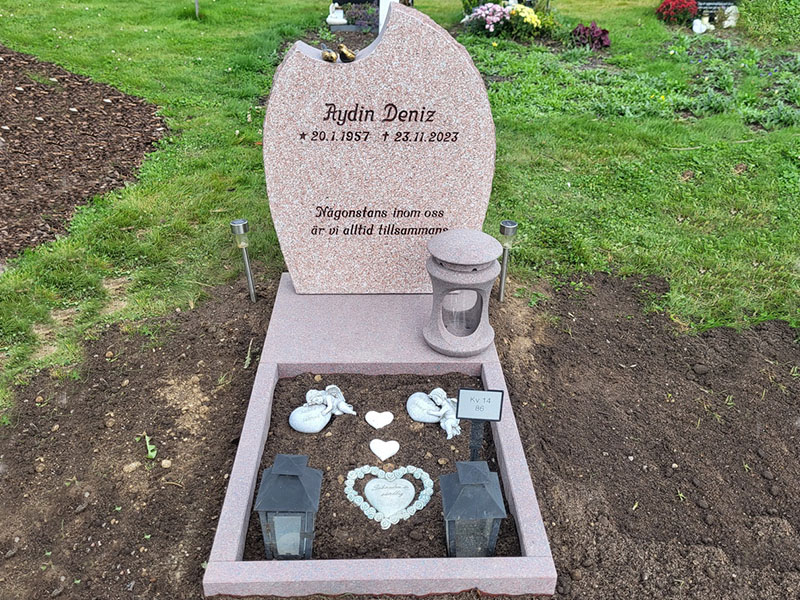 E047 in finely hammered Indian red granite. Extra-deep matt-polished base and flower border. Matt-polished granite lantern and bronze sparrows.