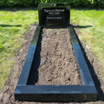 E046 i polerad svart granit. Försänkt antikvit gravyr, bredare sockel och en polerad gravram.