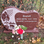 E061 in polished Indian red granite. Raised decorative elements and recessed, silver-painted text.