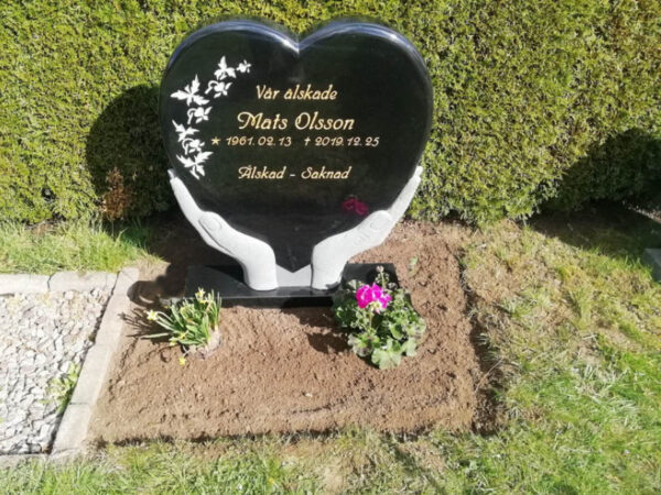 E005 in black granite. Recessed text gilded in gold and recessed decoration painted antique white.