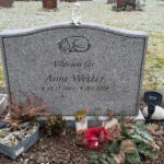 EN106 in flamed grey Bohus granite with matte-ground side surfaces. Deep-sandblasted engraving and a marble angel on the top.