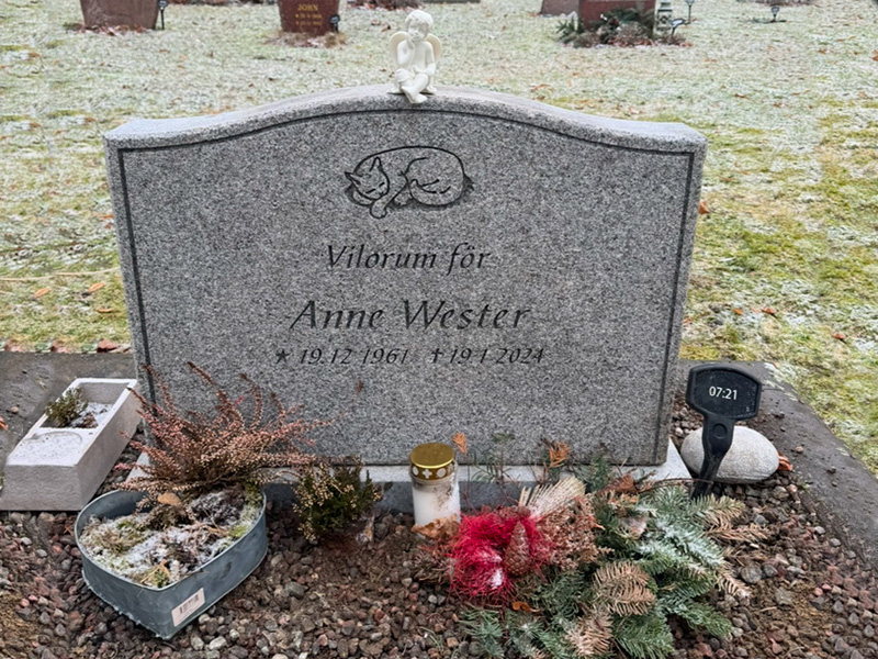 EN106 in flamed grey Bohus granite with matte-ground side surfaces. Deep-sandblasted engraving and a marble angel on the top.