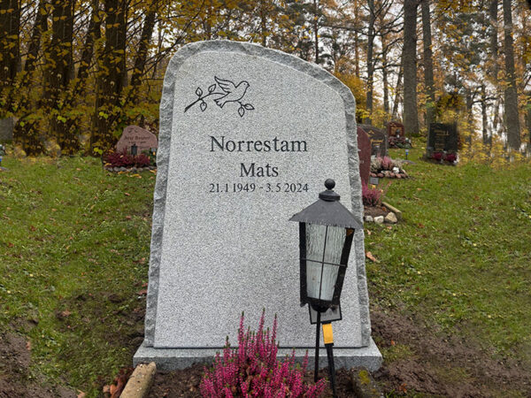 EN107 in fine-chiseled grey Kuru granite with rough-hewn edge and side surfaces. Deep-sandblasted engraving with stone gloss.